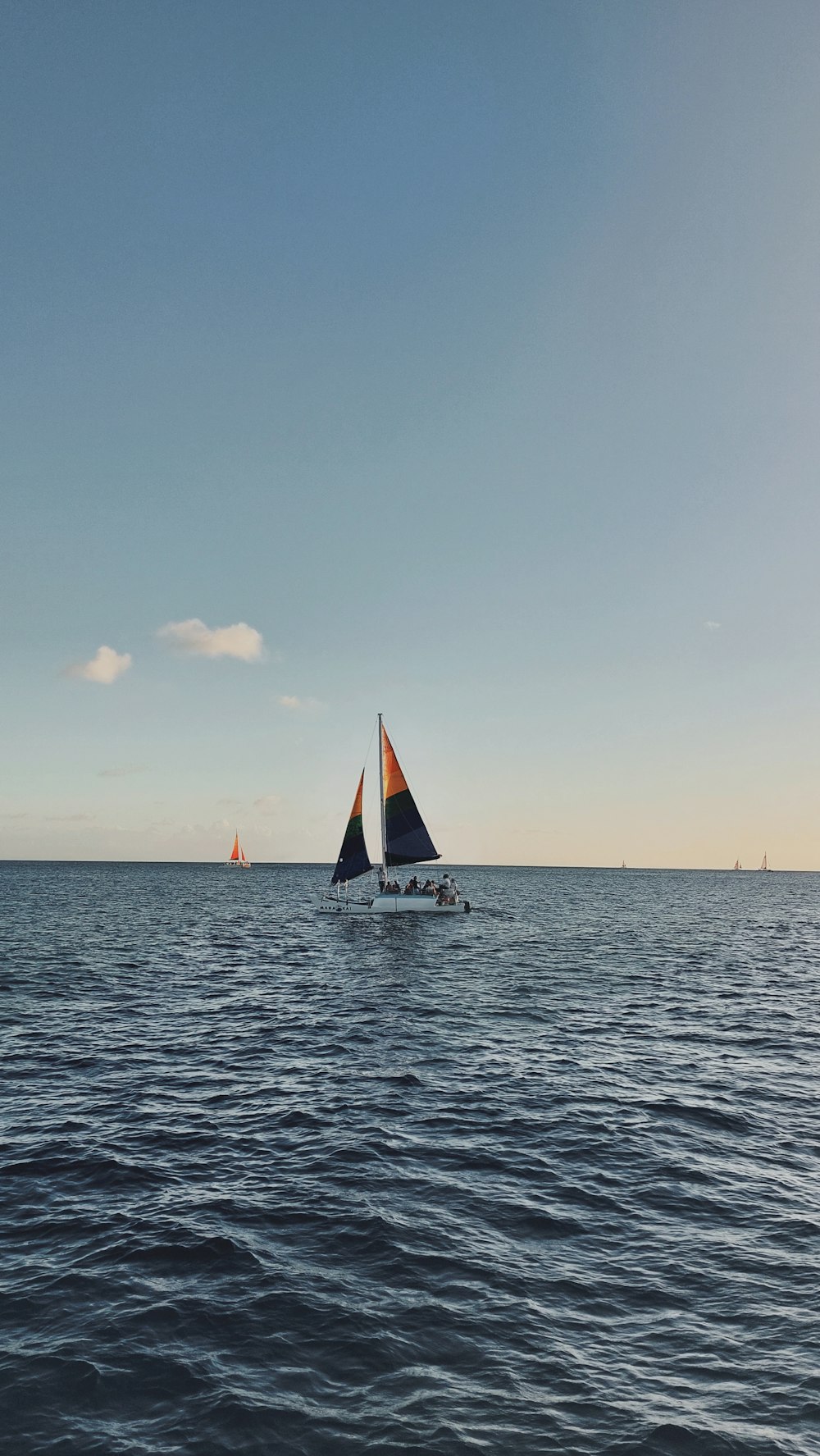 a couple of sail boats floating on top of a large body of water