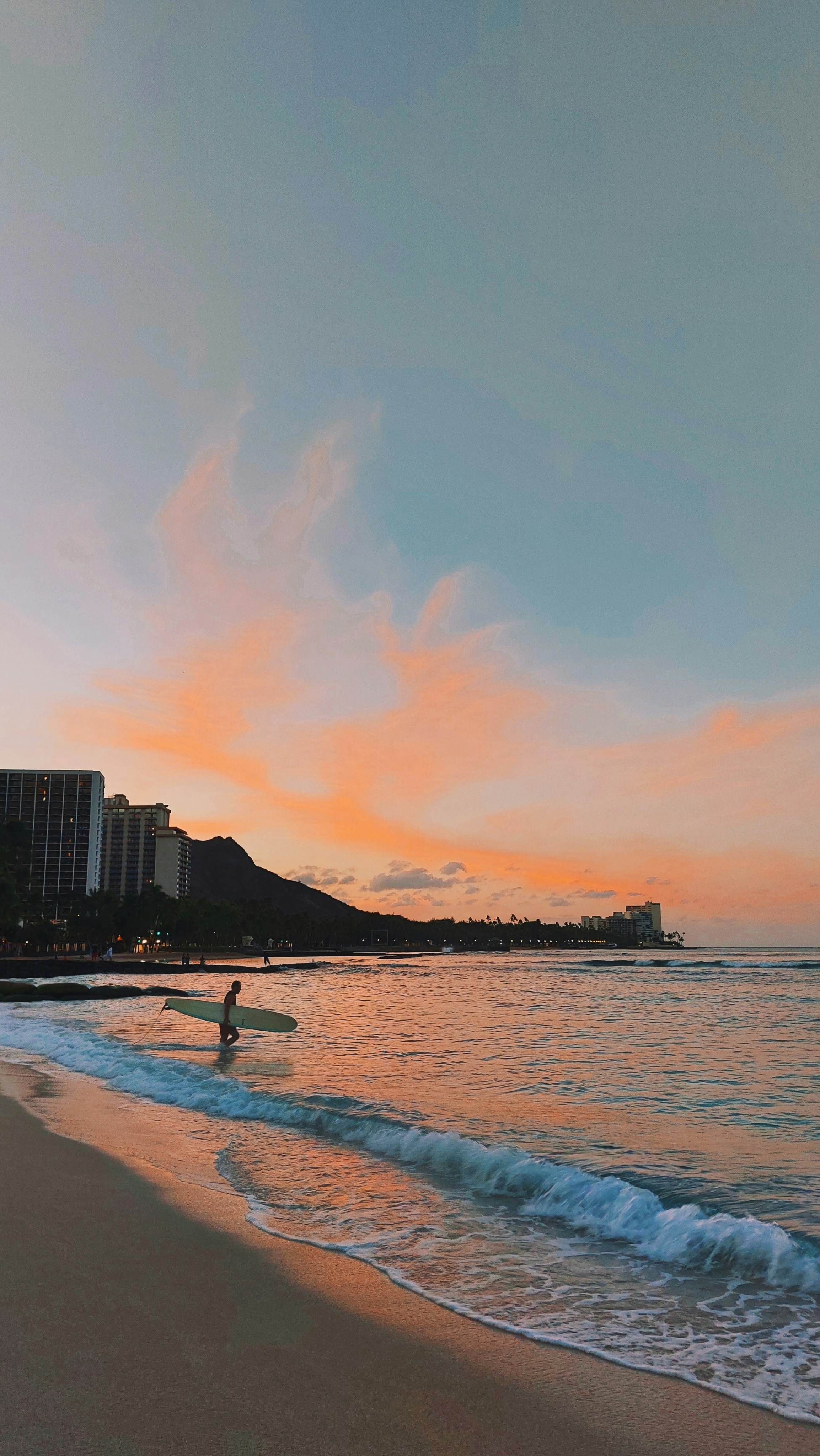 a person on a surfboard in the water at sunset