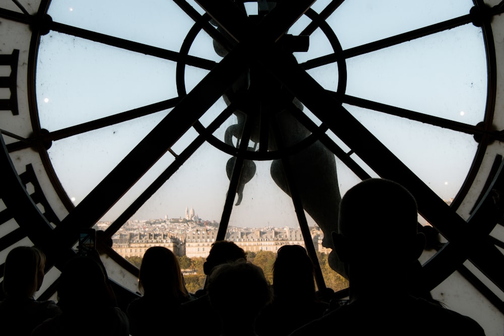 a group of people standing in front of a large clock