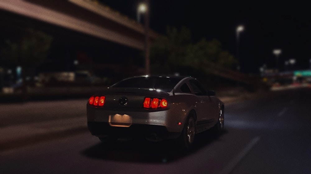 a car driving down a street at night