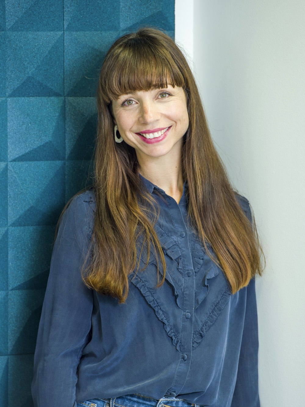 a woman standing in front of a blue wall