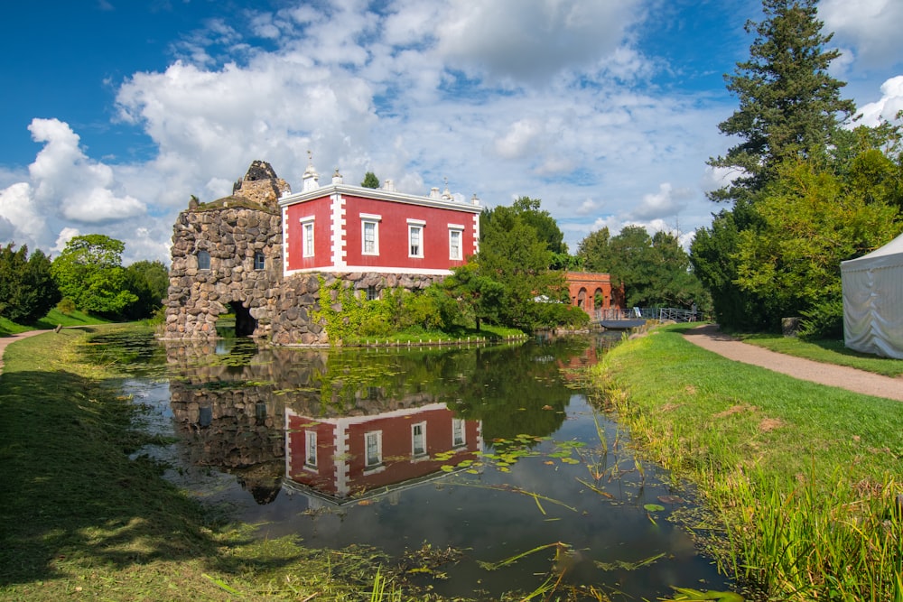 a red building sitting on top of a lush green field