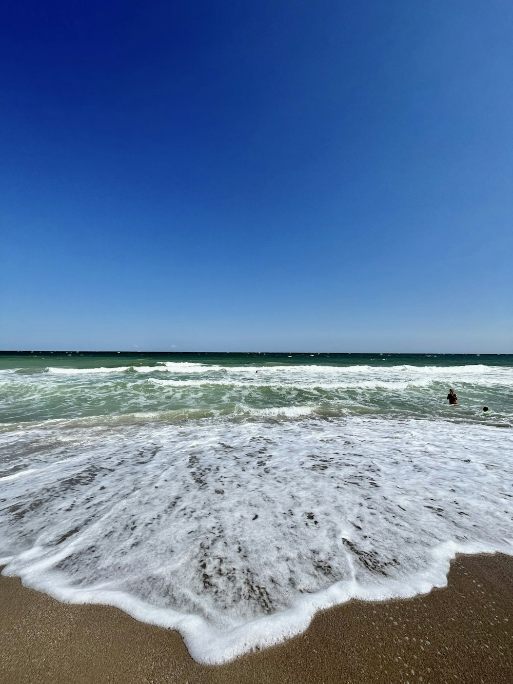 a sandy beach with waves coming in to shore