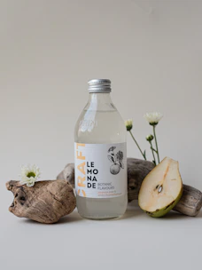 Artisan crafted natural beer bottles arranged with fresh fruits and herbs