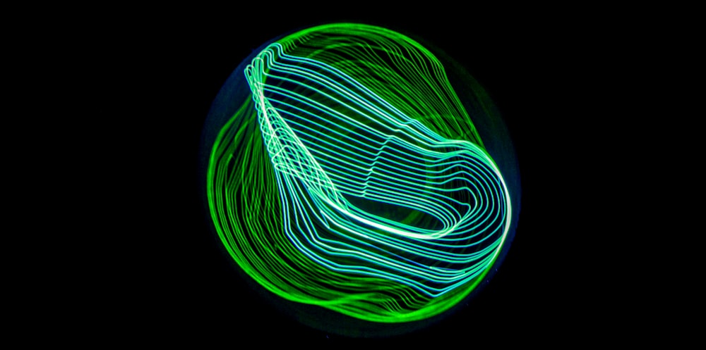 a green and white light painting on a black background
