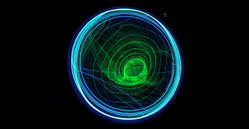 a green and blue light painting on a black background