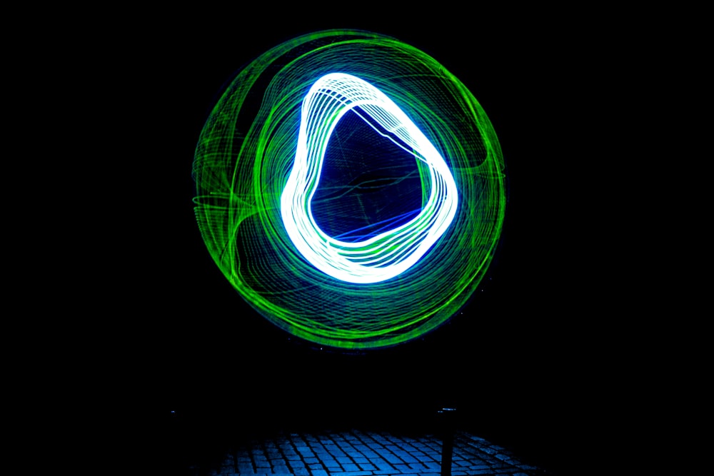 a green and white light painting on a black background