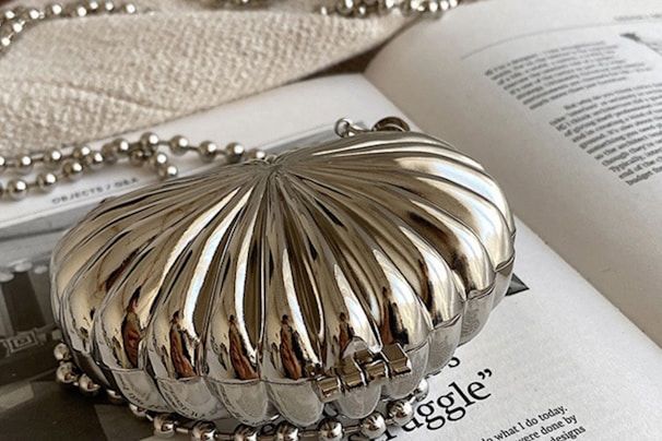 A bridal clutch adorned with delicate beadwork placed elegantly on a lace fabric.