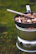 A rugged backpacker cooking a hearty stew beside a crackling campfire.