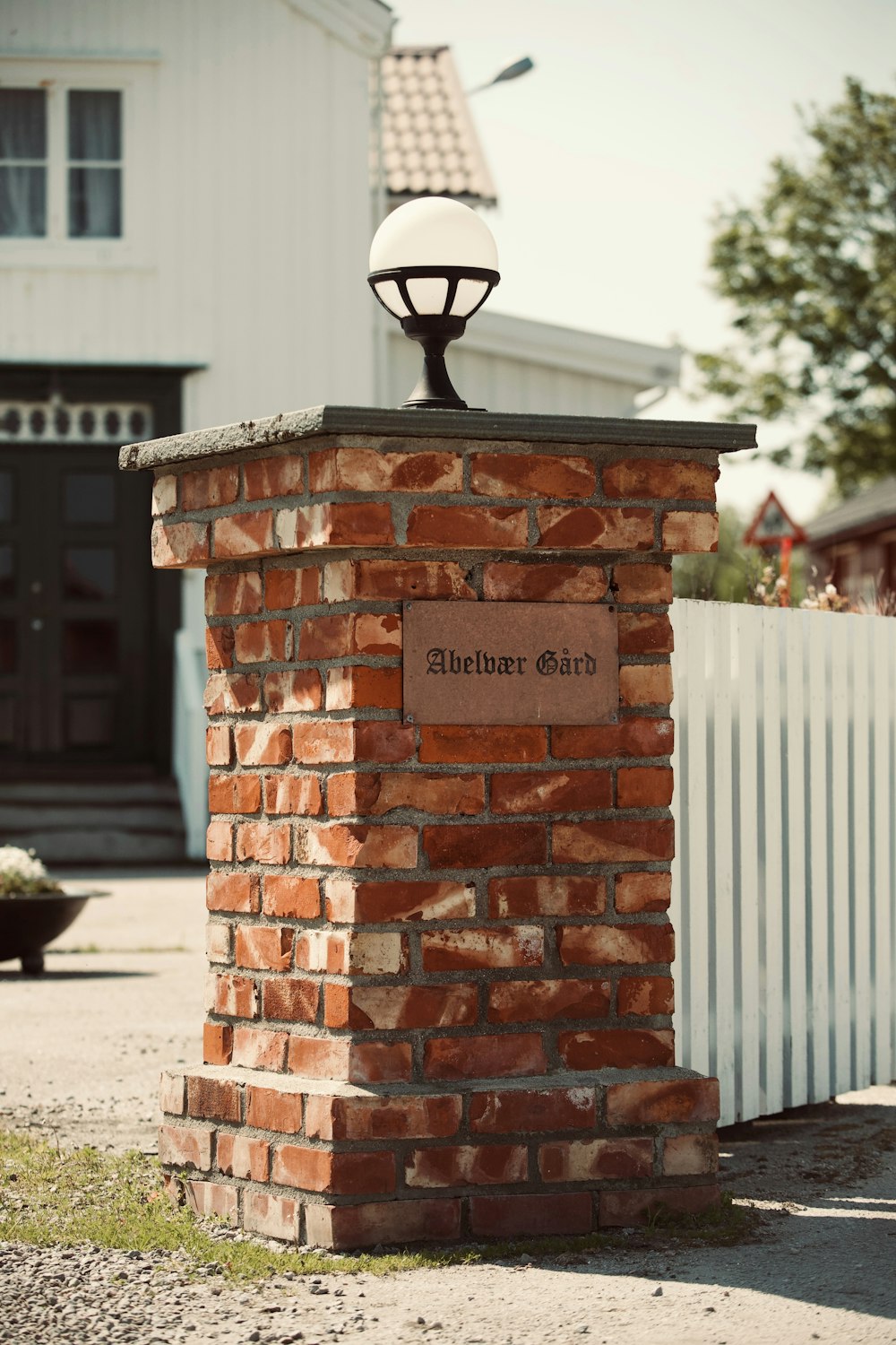 a brick post with a light on top of it