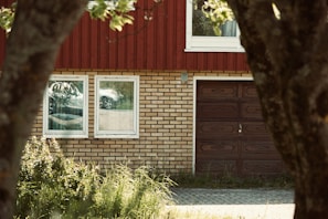 A classic wooden garage door framed by lush greenery.