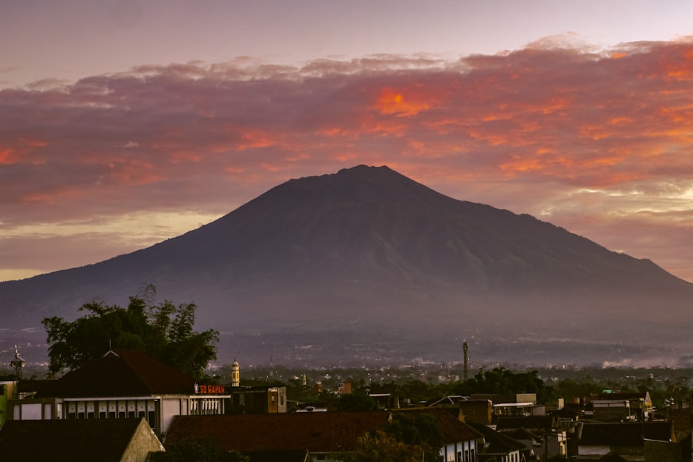 Ein Sonnenuntergangsblick auf eine Stadt mit einem Berg im Hintergrund