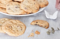A rustic wooden table displaying freshly baked cookies with chocolate chips.
