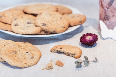 An assortment of golden cookies arranged on a vintage plate, with crumbs scattered invitingly around.