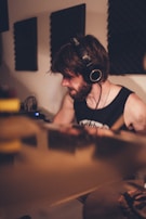 Close-up of a musician playing soulful R&B with headphones in a cozy home studio.