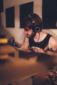 A musician in a studio, headphones on, passionately composing a song.