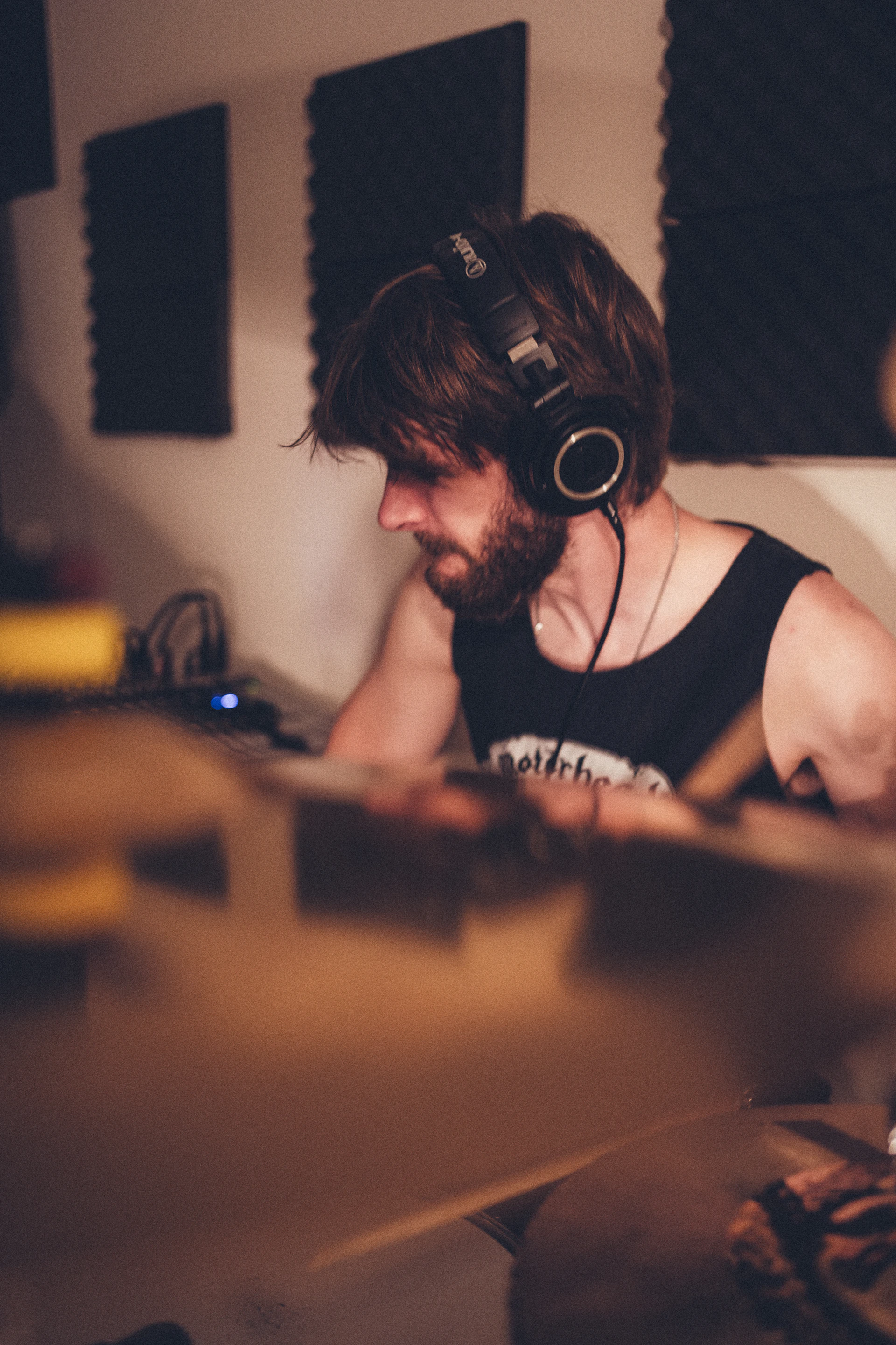 Close-up of a musician in a modern studio, headphones on, deeply immersed in recording a new track.