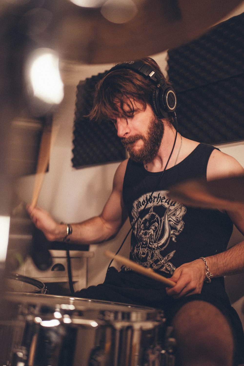 a man with headphones playing drums in a recording studio