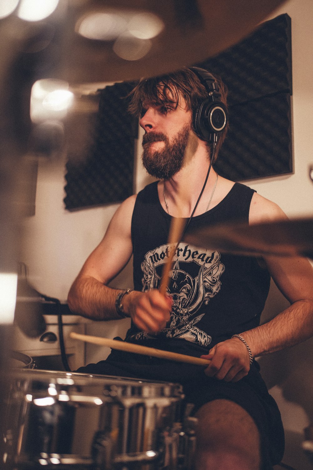 a man with headphones playing drums in a recording studio