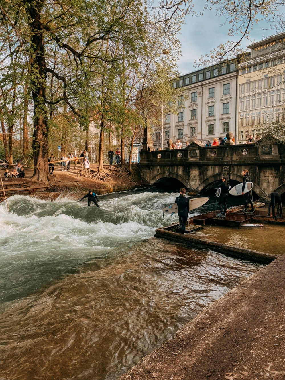 a group of people standing on the side of a river