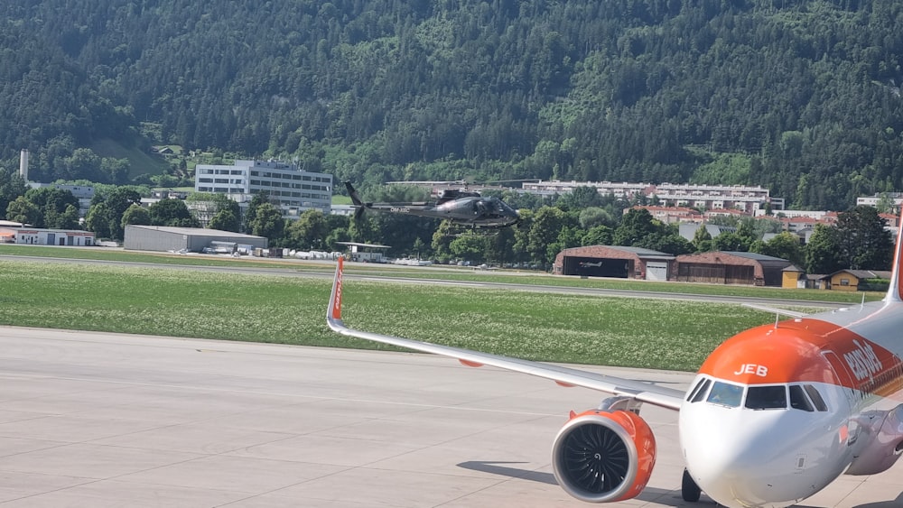 an orange and white airplane is on the runway