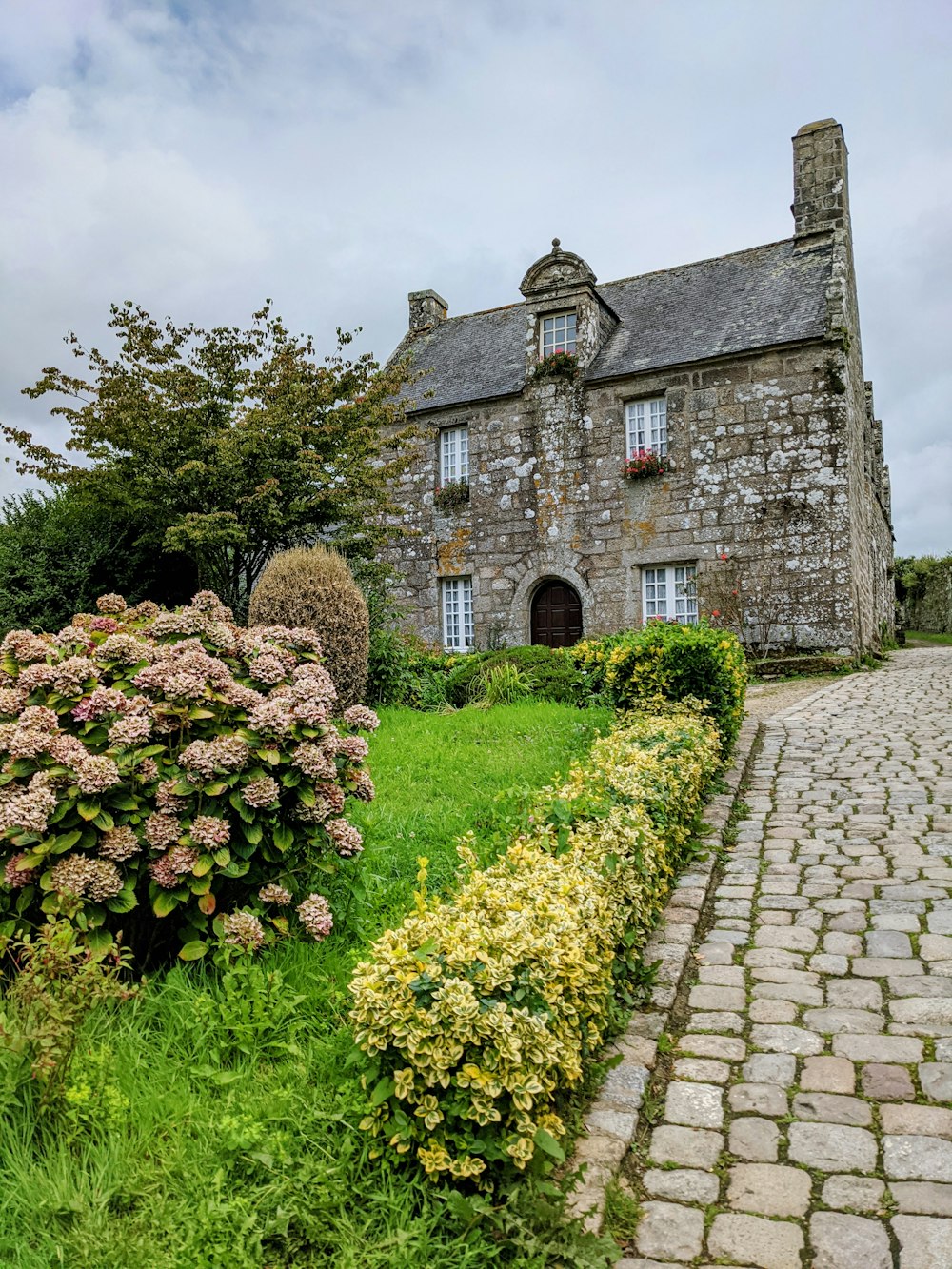 a stone house with a garden in front of it