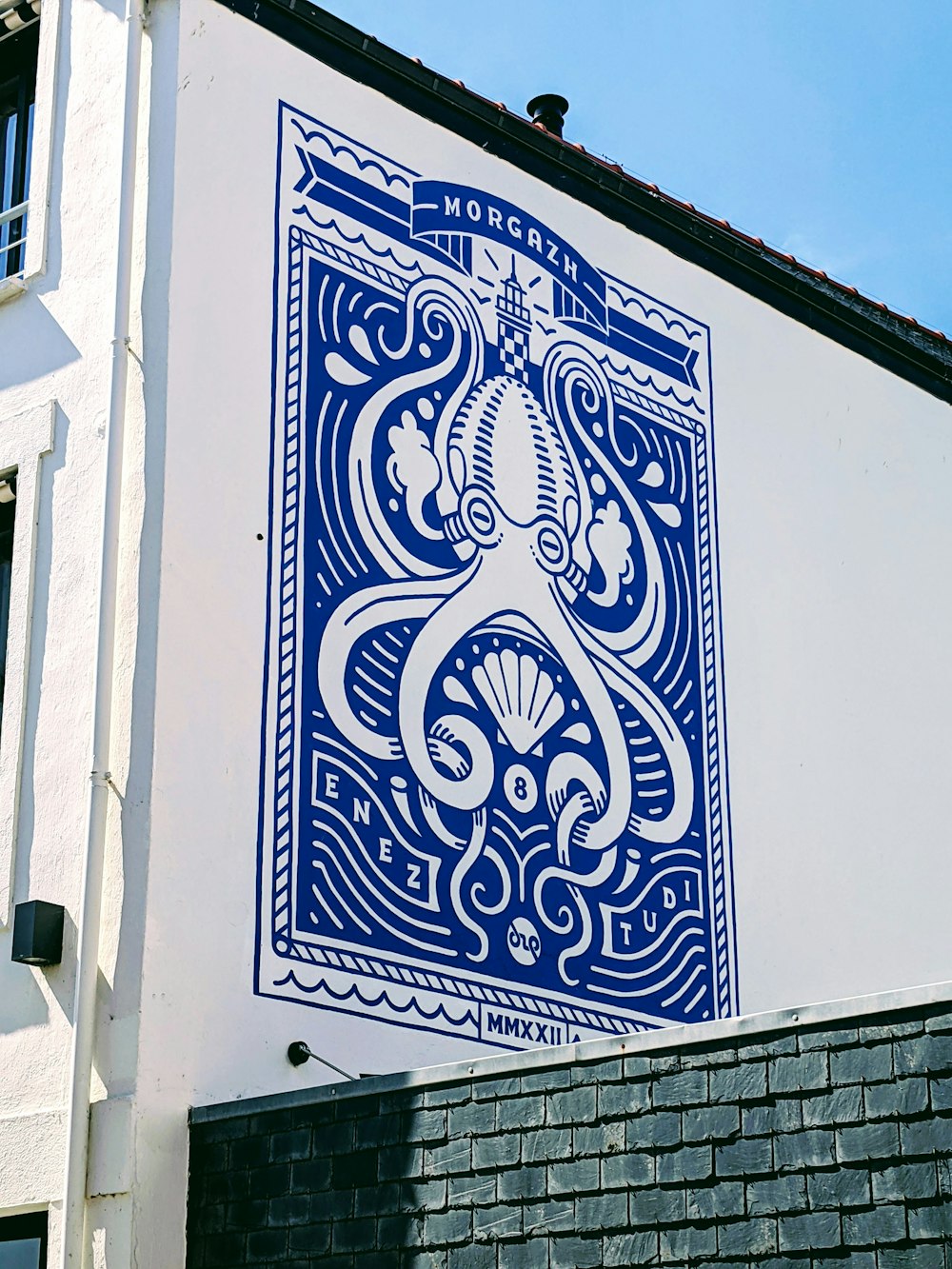 a blue and white tile mural on the side of a building