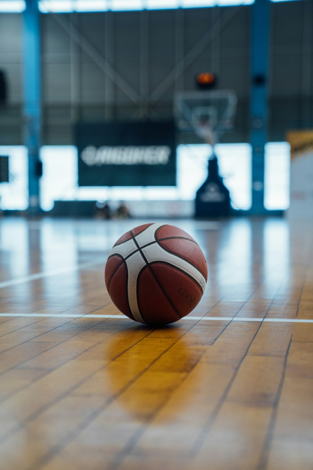 a basketball sitting on the floor in a gym