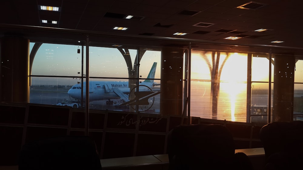 Um avião é visto através da janela de um aeroporto