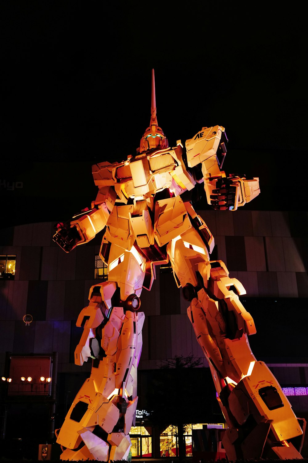 a statue of a giant robot is lit up at night