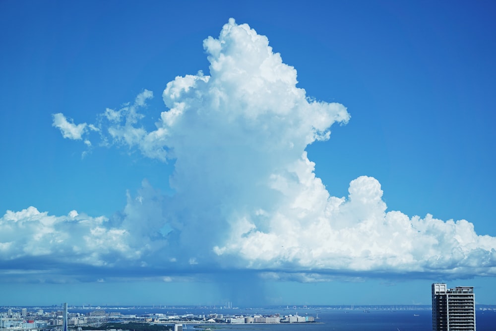 a large cloud is in the sky over a city