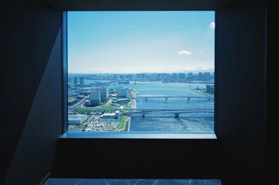 A sparkling clean window overlooking a vibrant cityscape on a clear day.