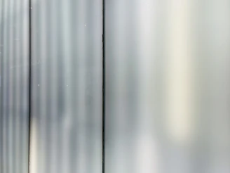 Close-up of a sleek glass panel reflecting soft blue light