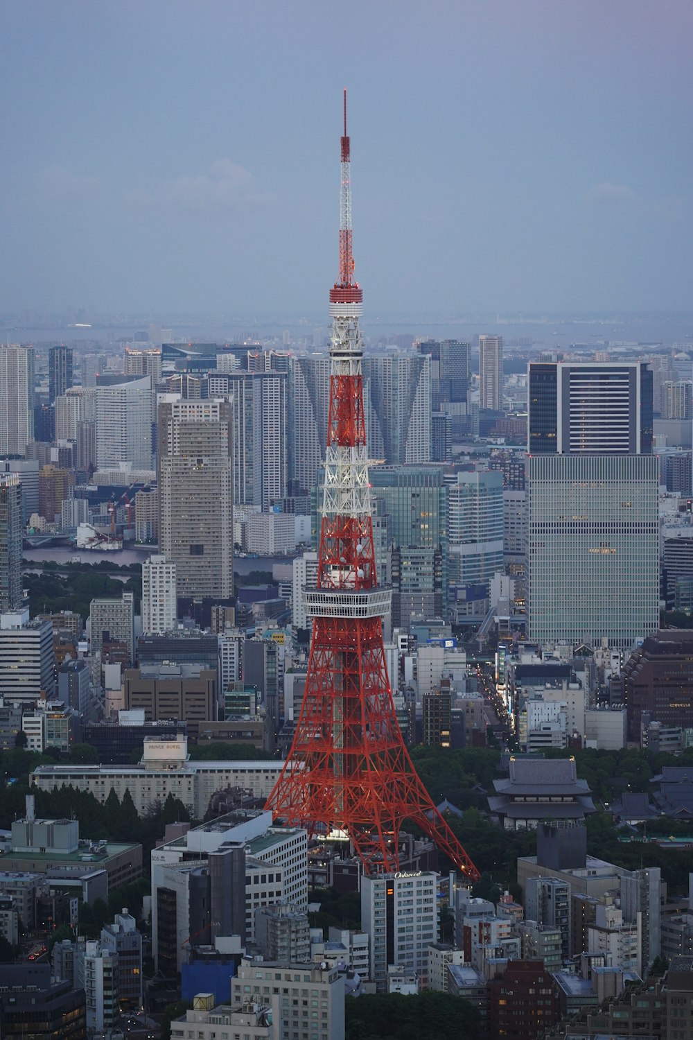a red and white tower in the middle of a city