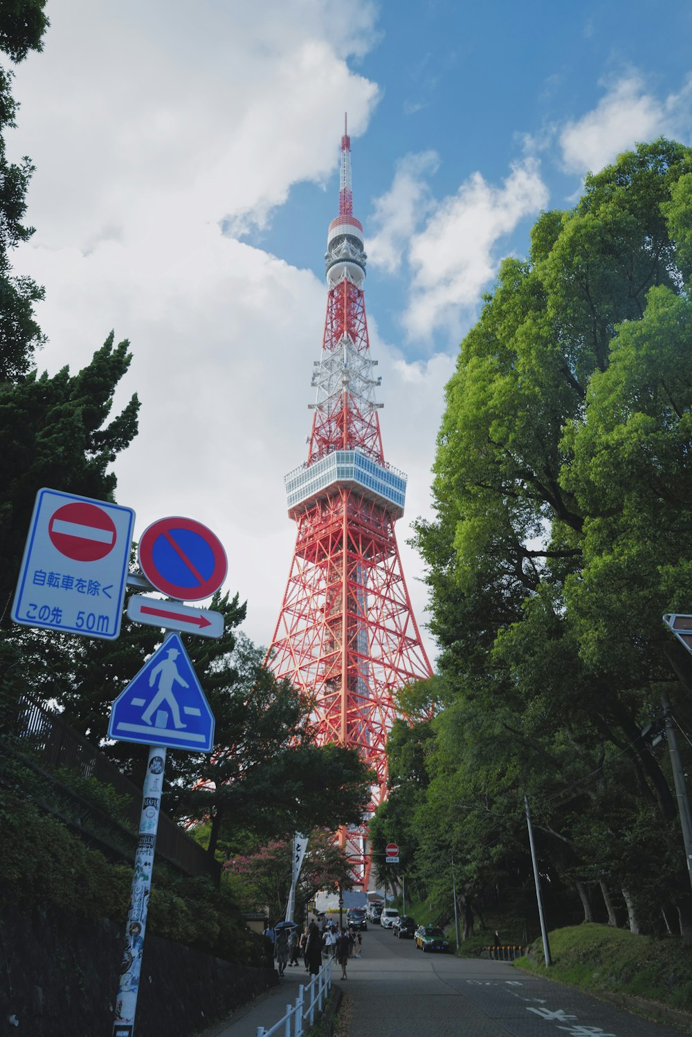 a tall red tower towering over a lush green forest