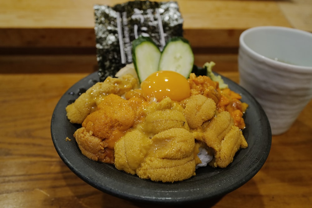 a plate of food on a table next to a cup