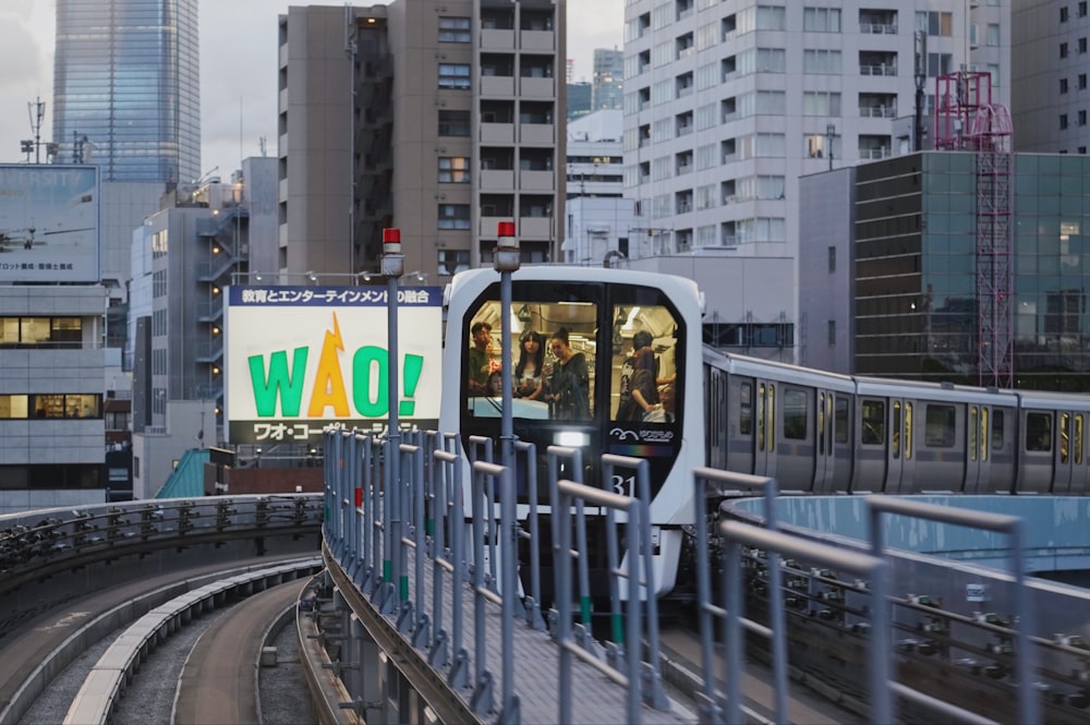 a train traveling through a city next to tall buildings