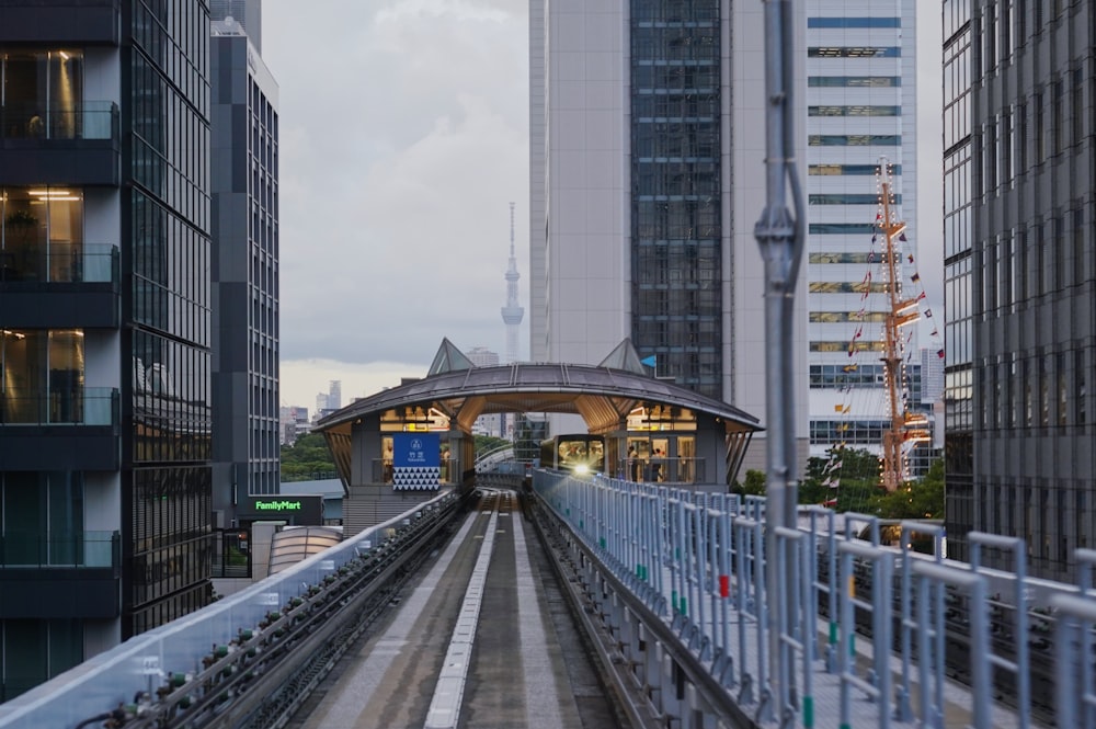 a train traveling down train tracks next to tall buildings