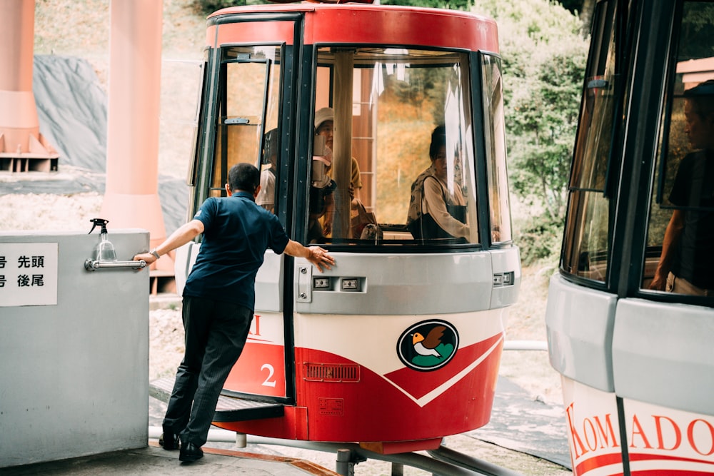 a man standing next to a red and white bus