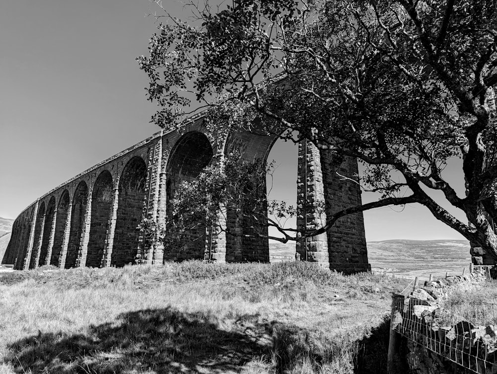 a black and white photo of an old bridge