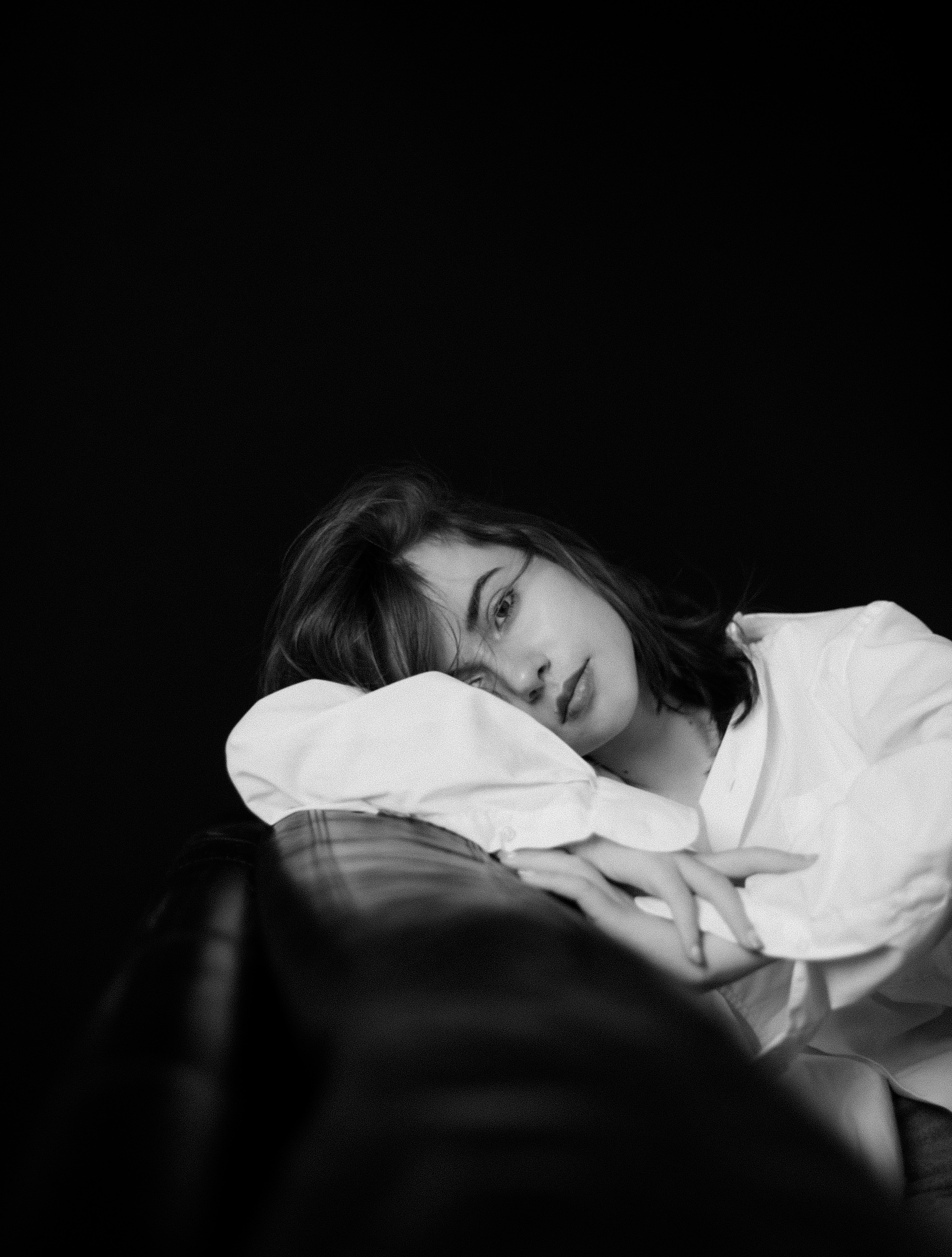 a black and white photo of a woman laying on a couch