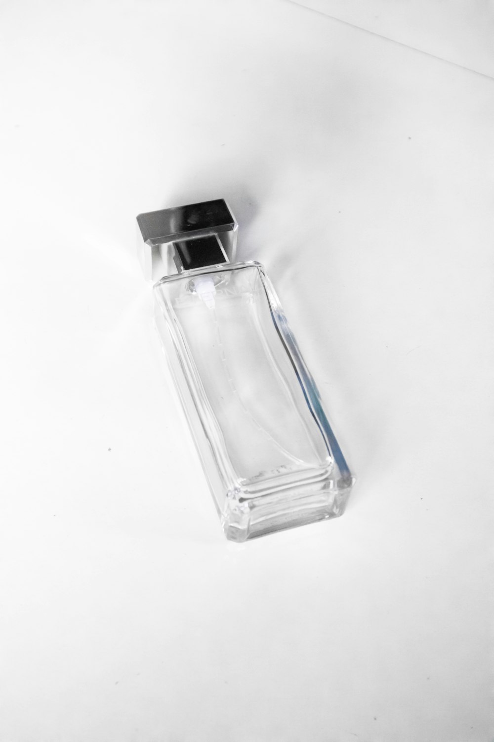 a bottle of perfume sitting on a white surface