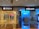 A hallway in a shopping mall features two bank outlets side by side: Bank of China (Hong Kong) on the left and Citibank on the right. Both banks have illuminated signs with their logos. The Bank of China section shows a closed office area with some ATMs in use by customers. The Citibank area has a bright, blue-lit interior with a welcoming entrance.