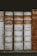 A row of antique leather-bound books with aged spines and labels, featuring volumes of theological or canonical texts. The books are predominantly weathered, in shades of brown and cream, with handwritten and printed text on their spines.