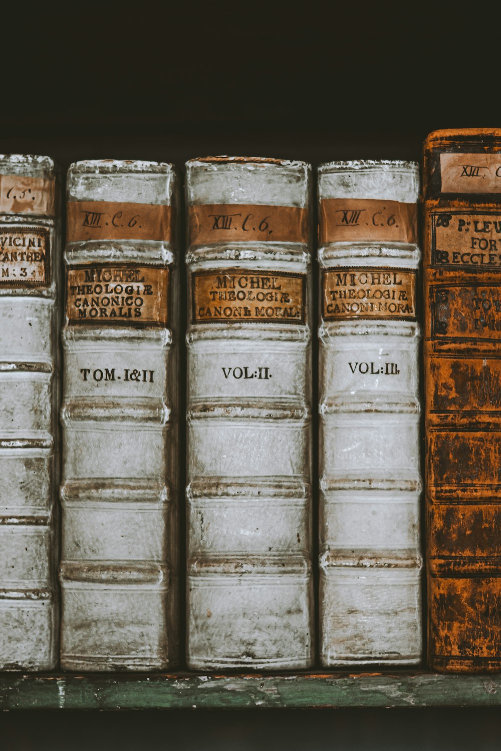 a row of old books sitting on a shelf