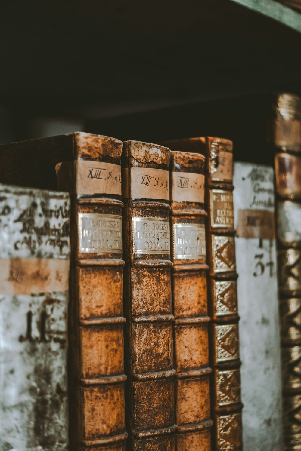 three old books are sitting on a shelf