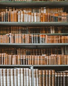Bookshelf filled with legal books and golden decorative elements in an office.