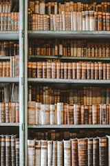 A vintage sepia-toned photograph of an old library filled with ancient books and historical artifacts.