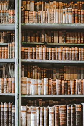 A vintage sepia-toned photograph of an old library filled with ancient books and historical artifacts.