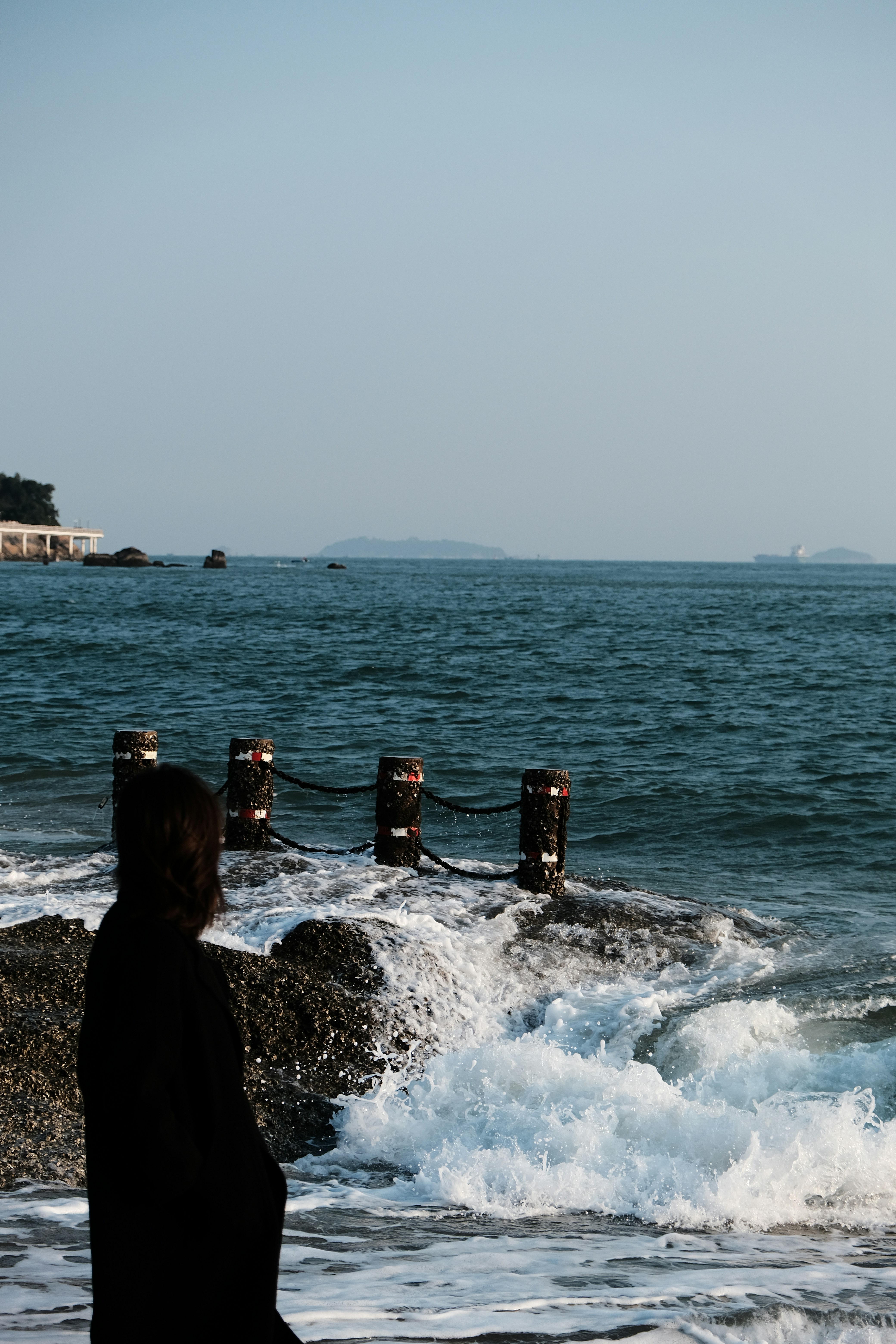 A woman standing on top of a beach next to the ocean photo – Free Image ...